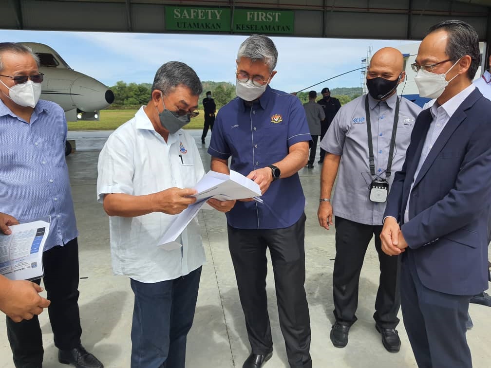 Dr Joachim (second left) handing over a document to Tengku Zafrul (centre)